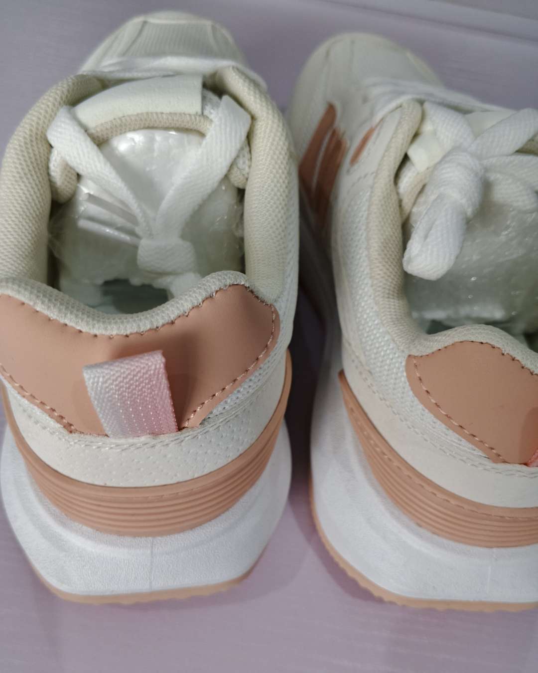 white and peach New Balance sneakers