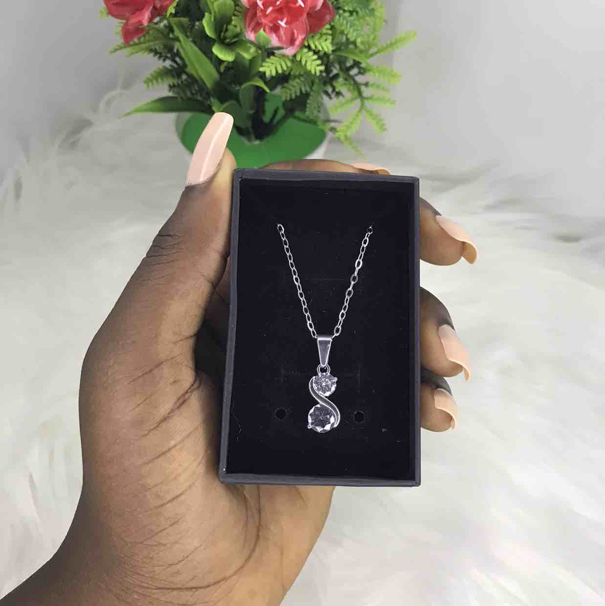 Silver necklace and crystal pendant.